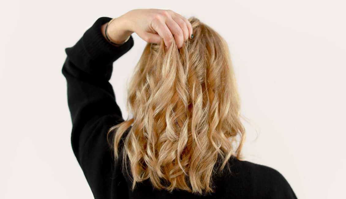Image of back of head esalon client courtney with a custom buttery blonde hair color trending for fall