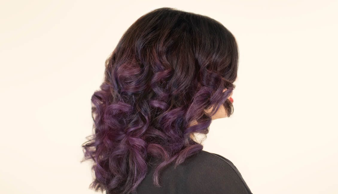 Image of esalon client with mulled wine custom hair color which has a dark base shade and purple ends