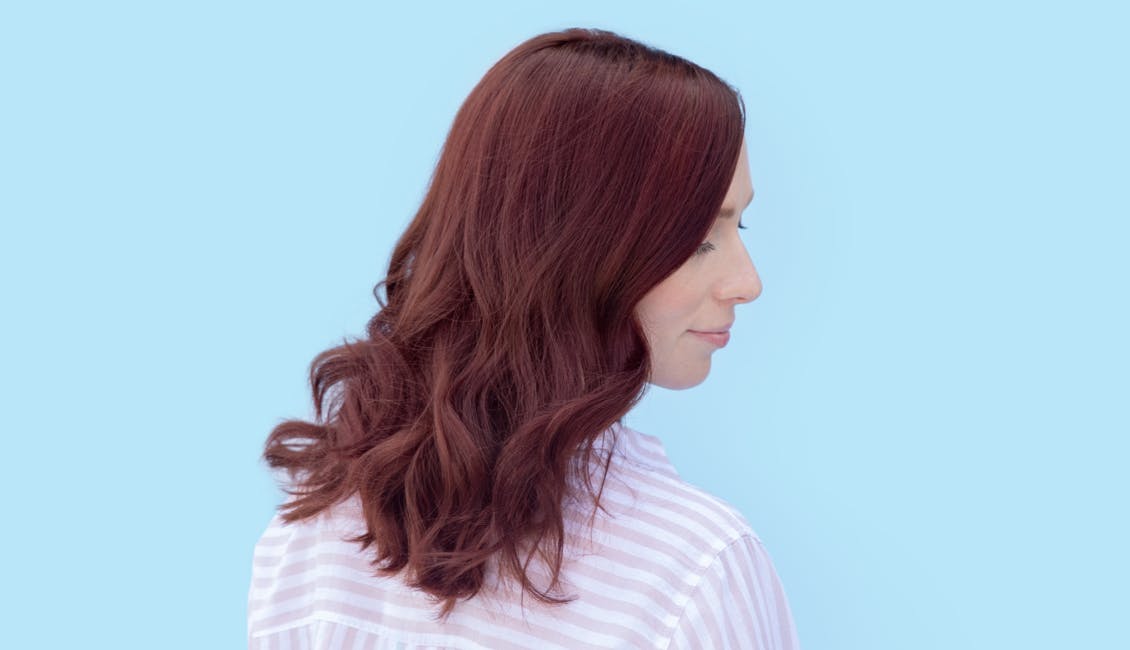 Image of woman from the side with esalon custom home hair color in bright warm merlot trending for spring