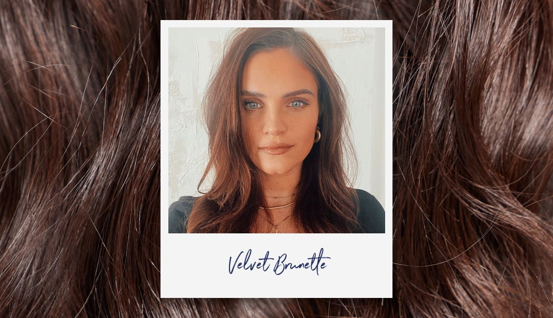 Woman looking straight into camera with layered brunette hair.