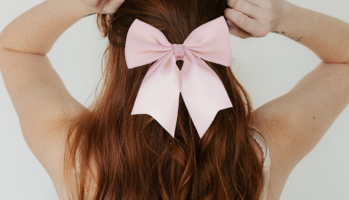 Woman with a large pink bow in her hair. 
