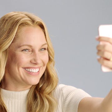 Image of blonde woman taking a selfie with her iPhone