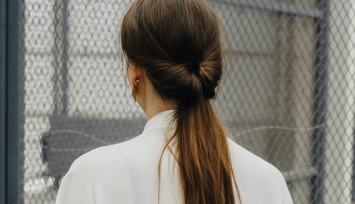 Back of woman's head showing a twisted ponytail. 