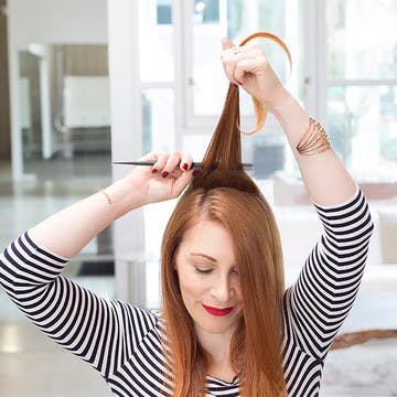 Image of woman gently teasing her custom hair color without damage using a fine-toothed comb