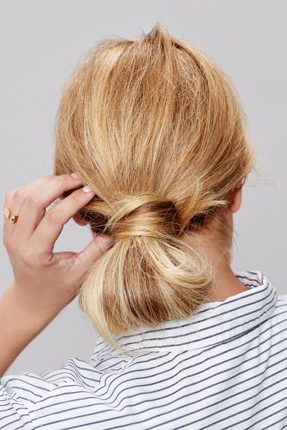 Image of esalon client renee's back of head shot with blonde hair and highlights in a low wrap-around bun updo in this how to article featured in color mastery