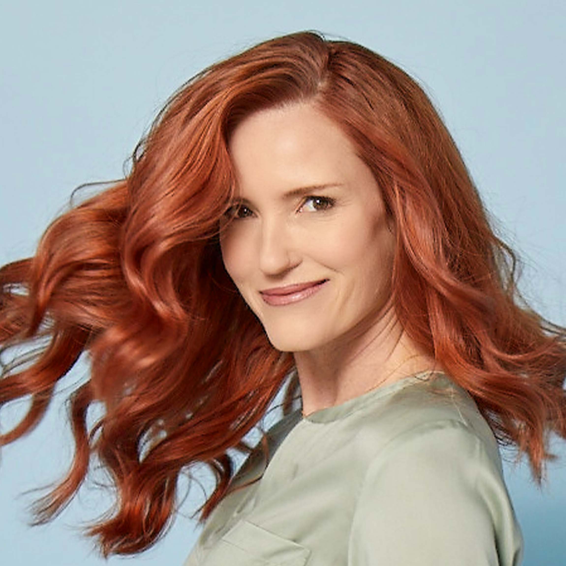 A smiling woman with curly red hair