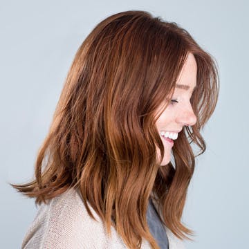 Image of woman with copper brunette custom esalon hair color trending for summer