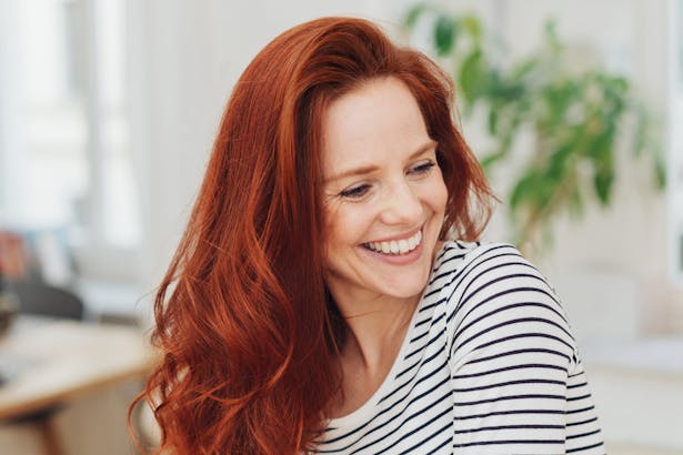 Smiling woman with long red hair. 