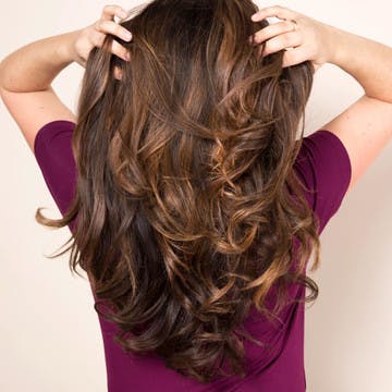 Image of woman running her hands through luscious, hydrated, healthy hair