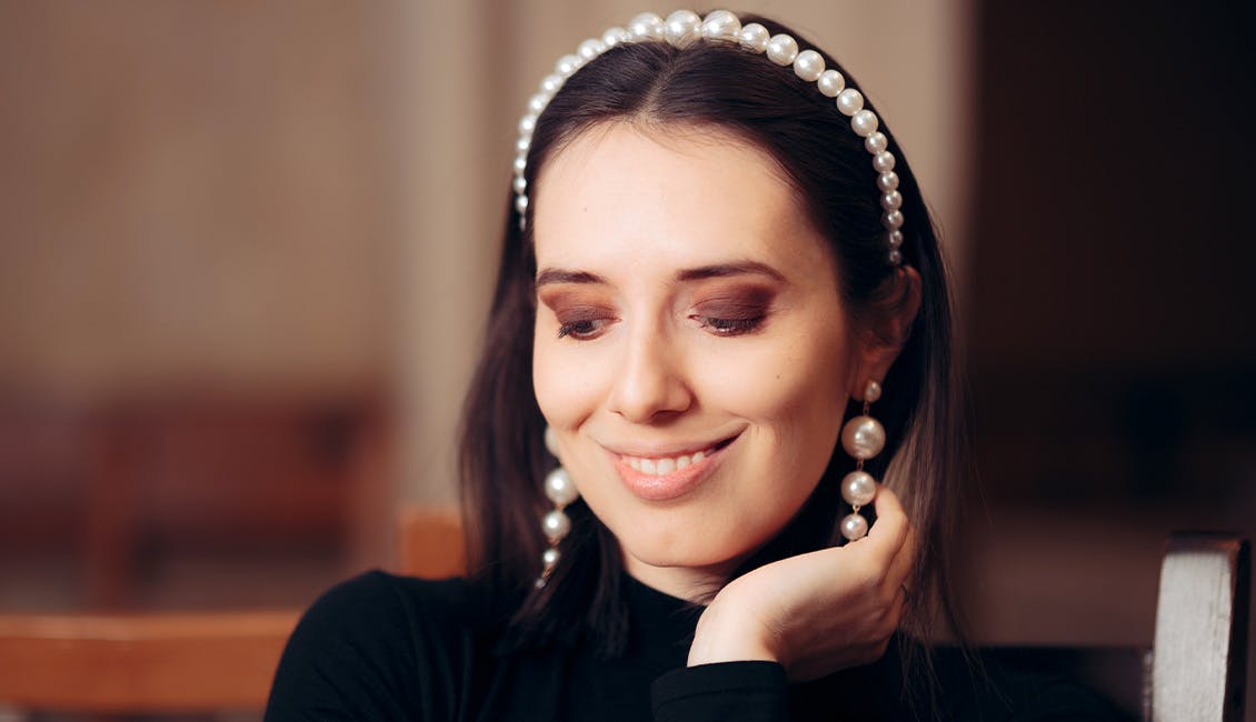 Woman with a pearl-laden headband. 