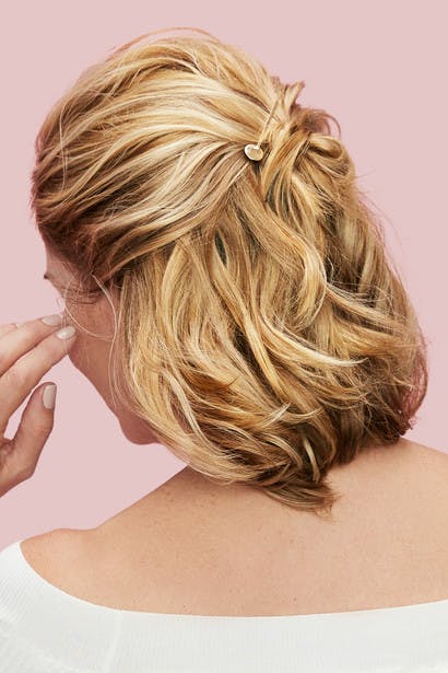 Image of esalon client victoria's back of head with blonde hair and highlights in a half-up-half-down easy updo with beautiful gold pins to hold hair as hero image in how to article featured on color mastery