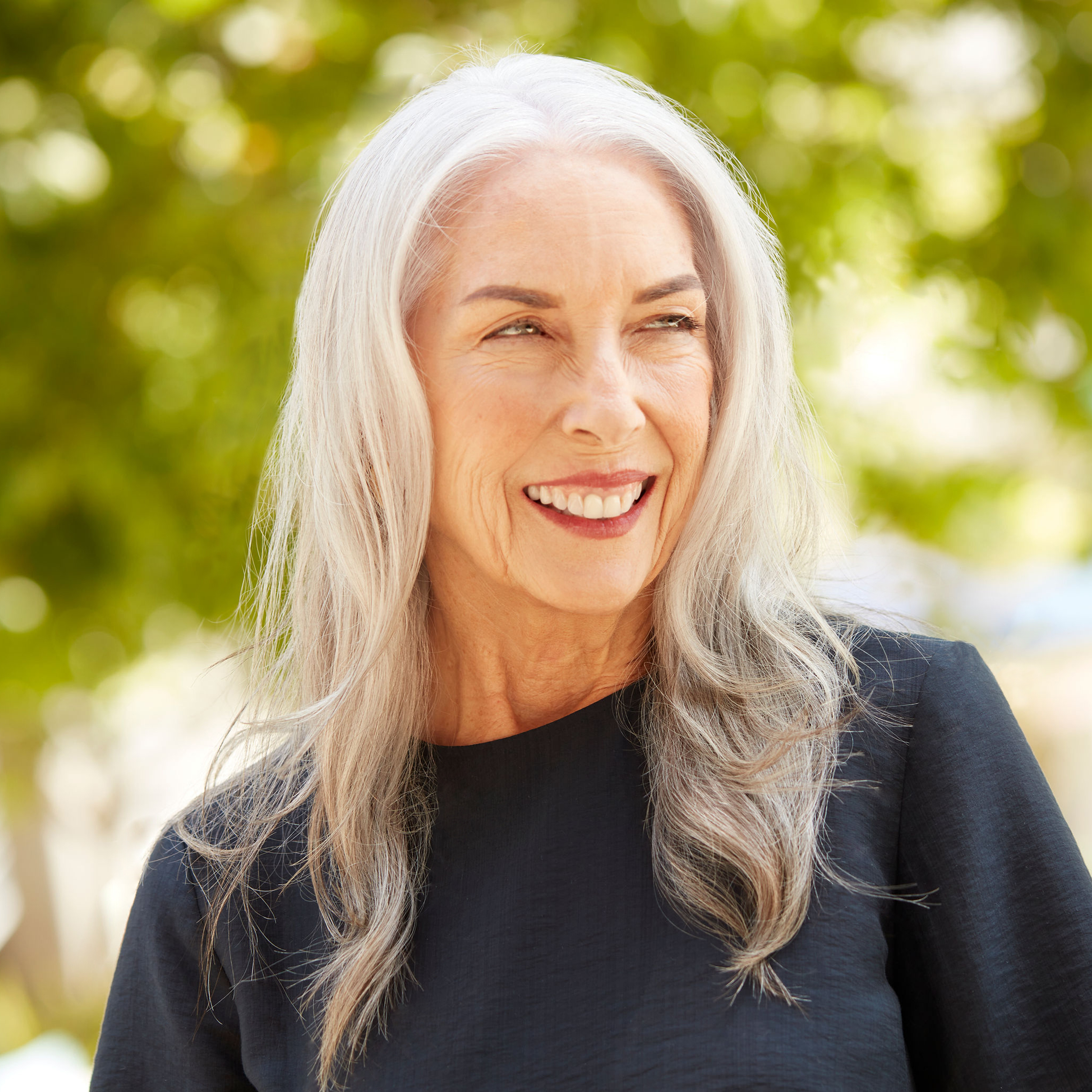 Woman smiling with gorgeous gray hair. 