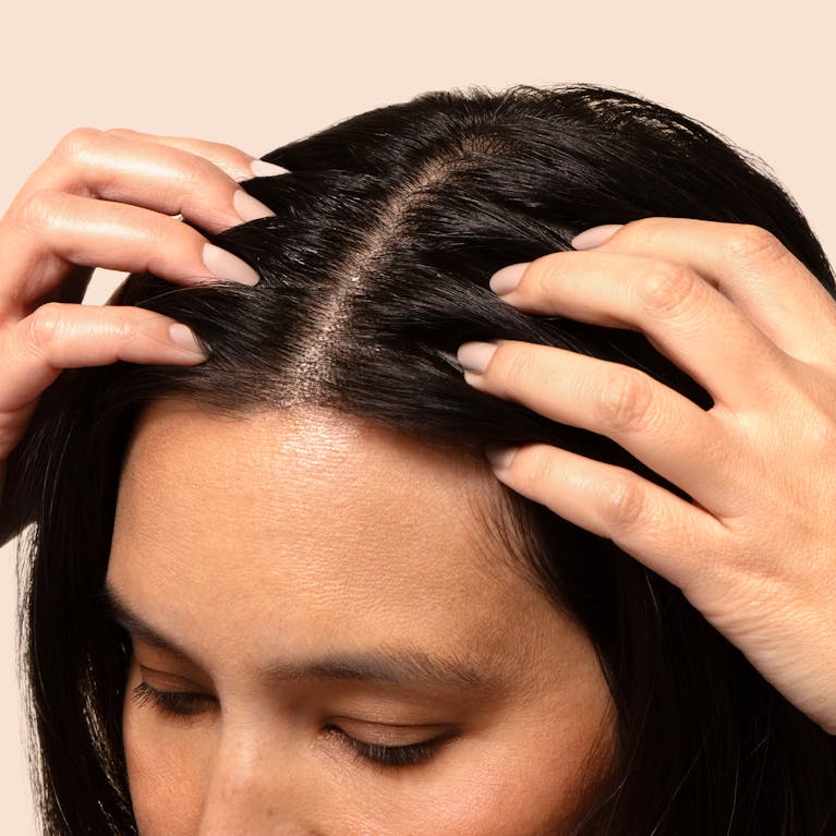 Close up of woman's partline and she is massaging it with her fingers.