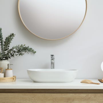 Very clean bathroom counter with bamboo accents and a bouquet of eucalyptus. 