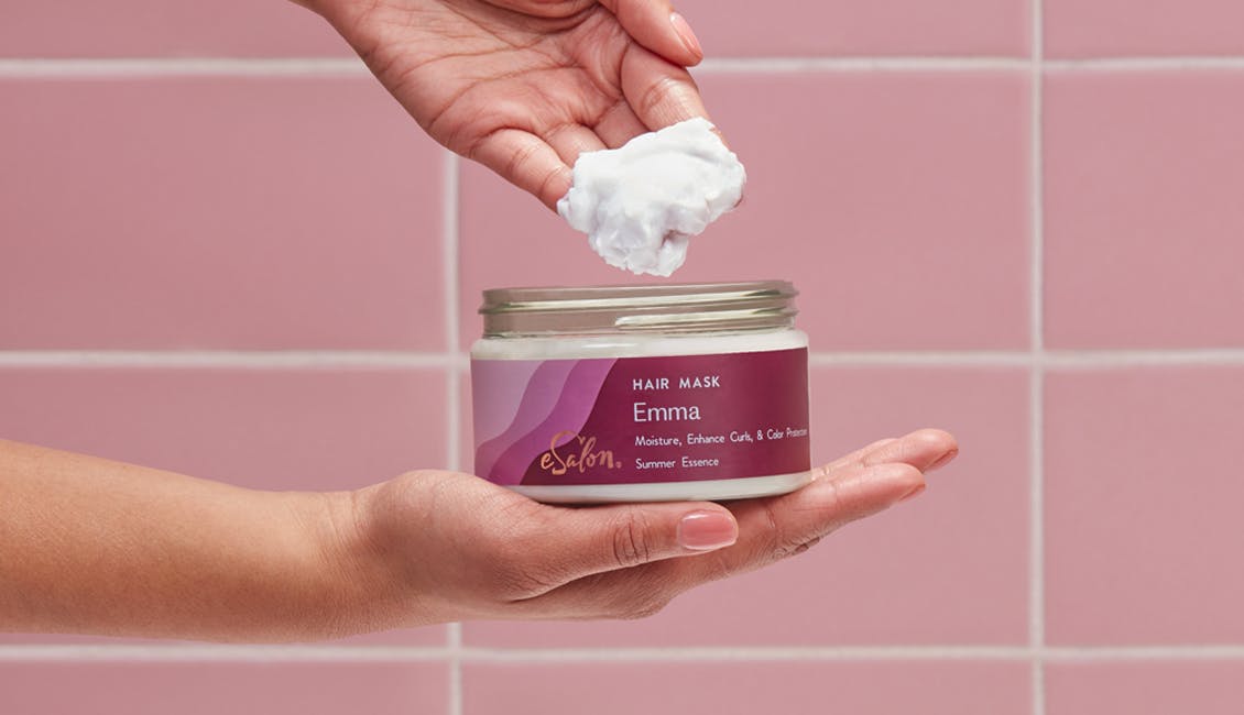 Person scooping a handful of the custom hair mask out of the jar. 