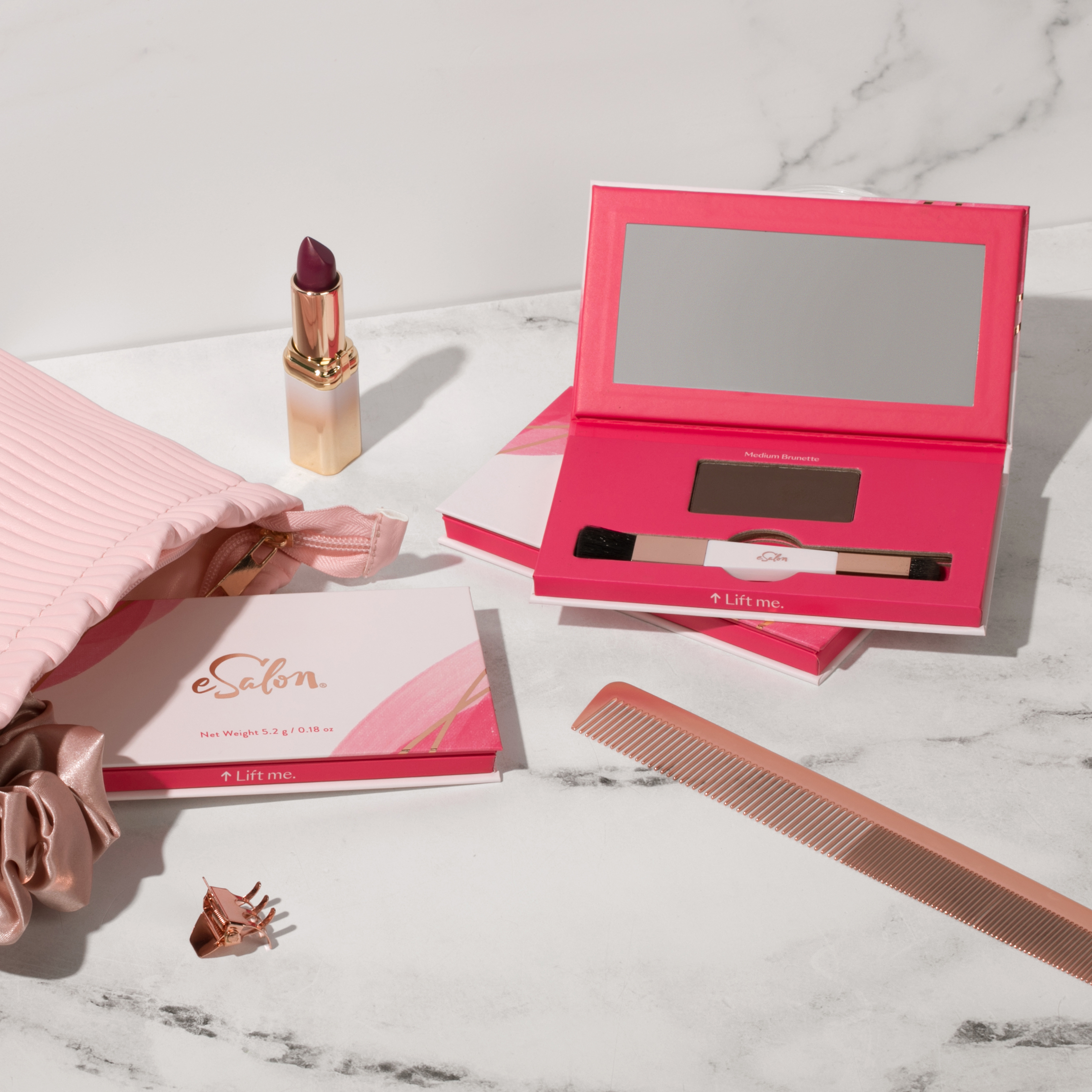 Small makeup bag filled with accessories like a comb, scrunchie, and Conceal & Cover Root Powder. 