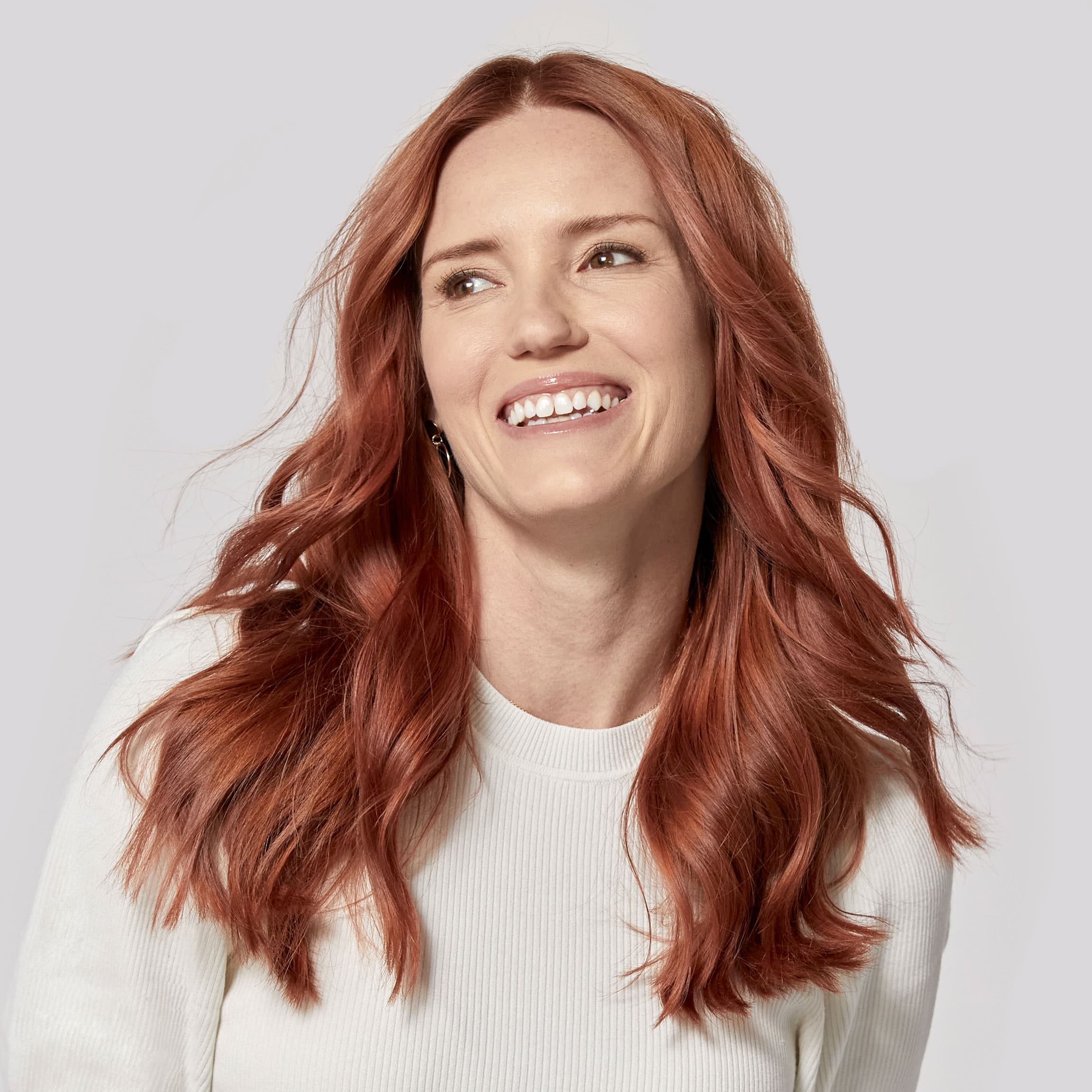 Woman with dark red hair laughing. 