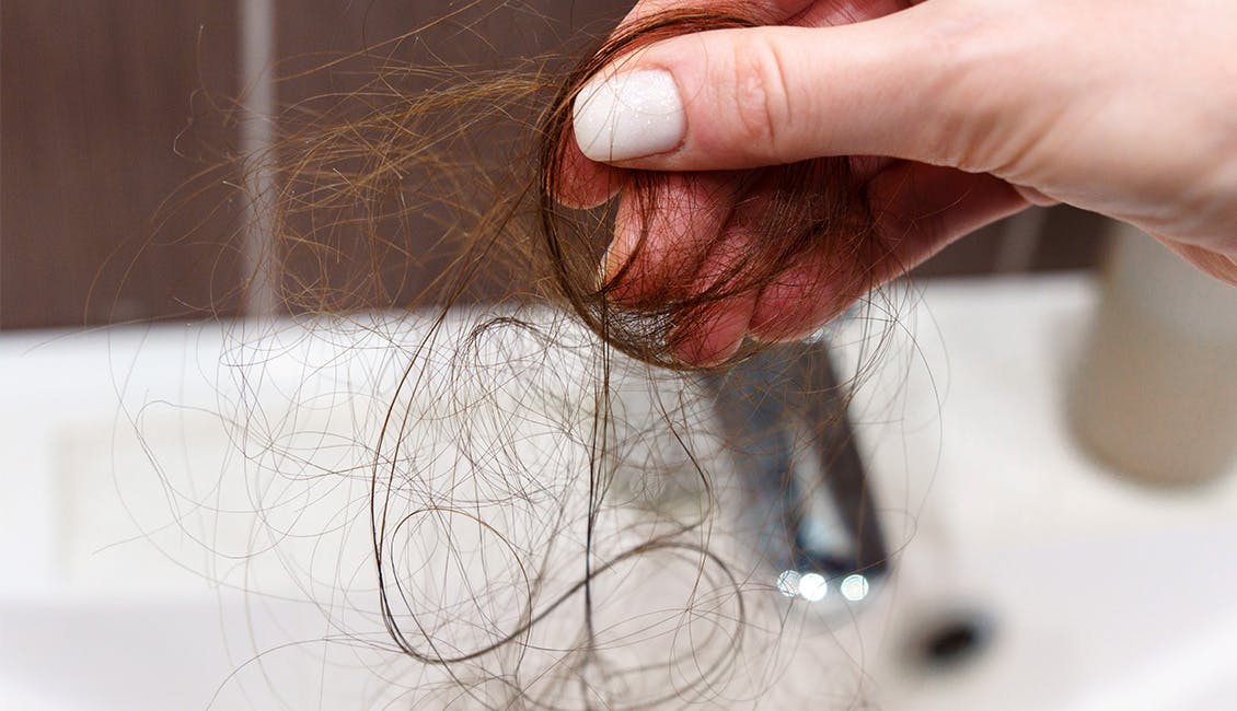 Person holding a clump of hair.