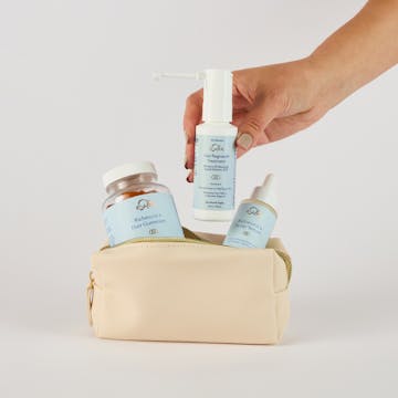 Person placing their custom hair growth routine into a toiletry bag.