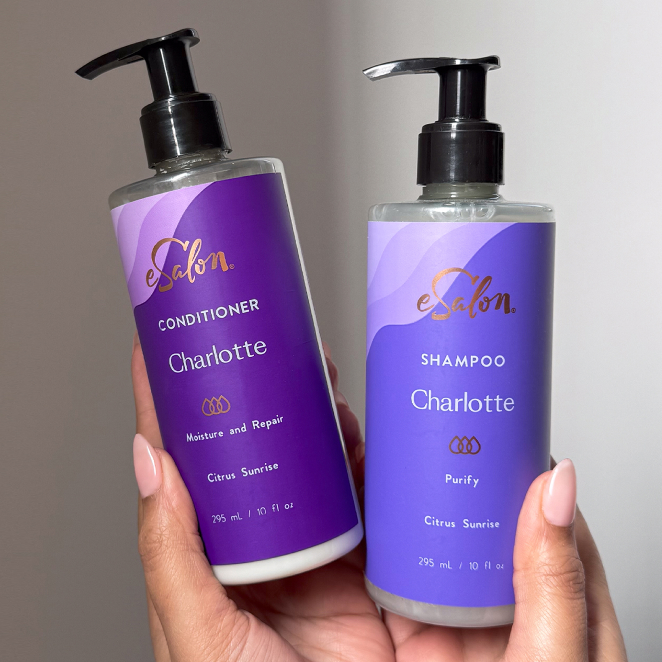 Two hands holding up their personalized shampoo and conditioner from eSalon.