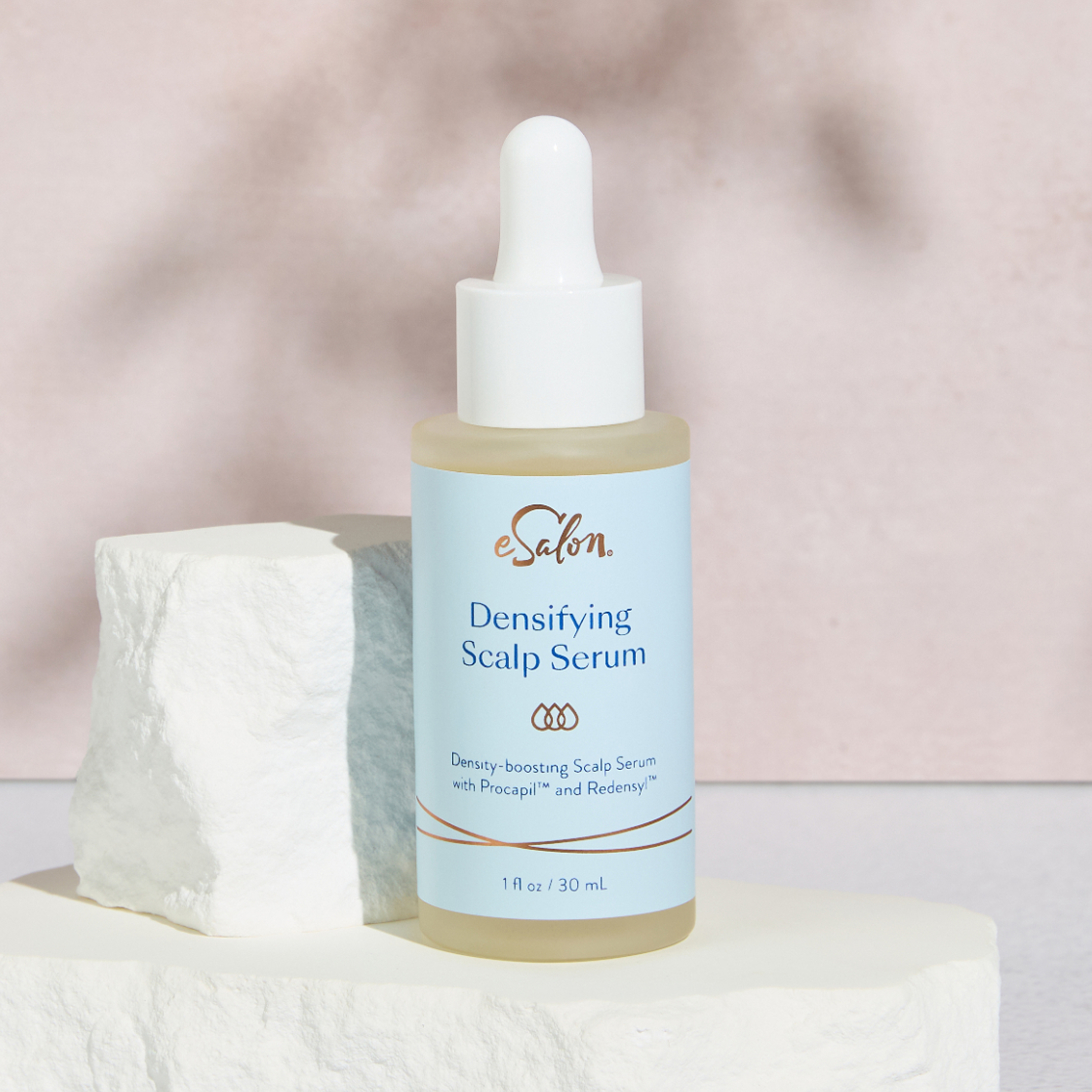 Bottle of Densifying Scalp Serum on bathroom counter.