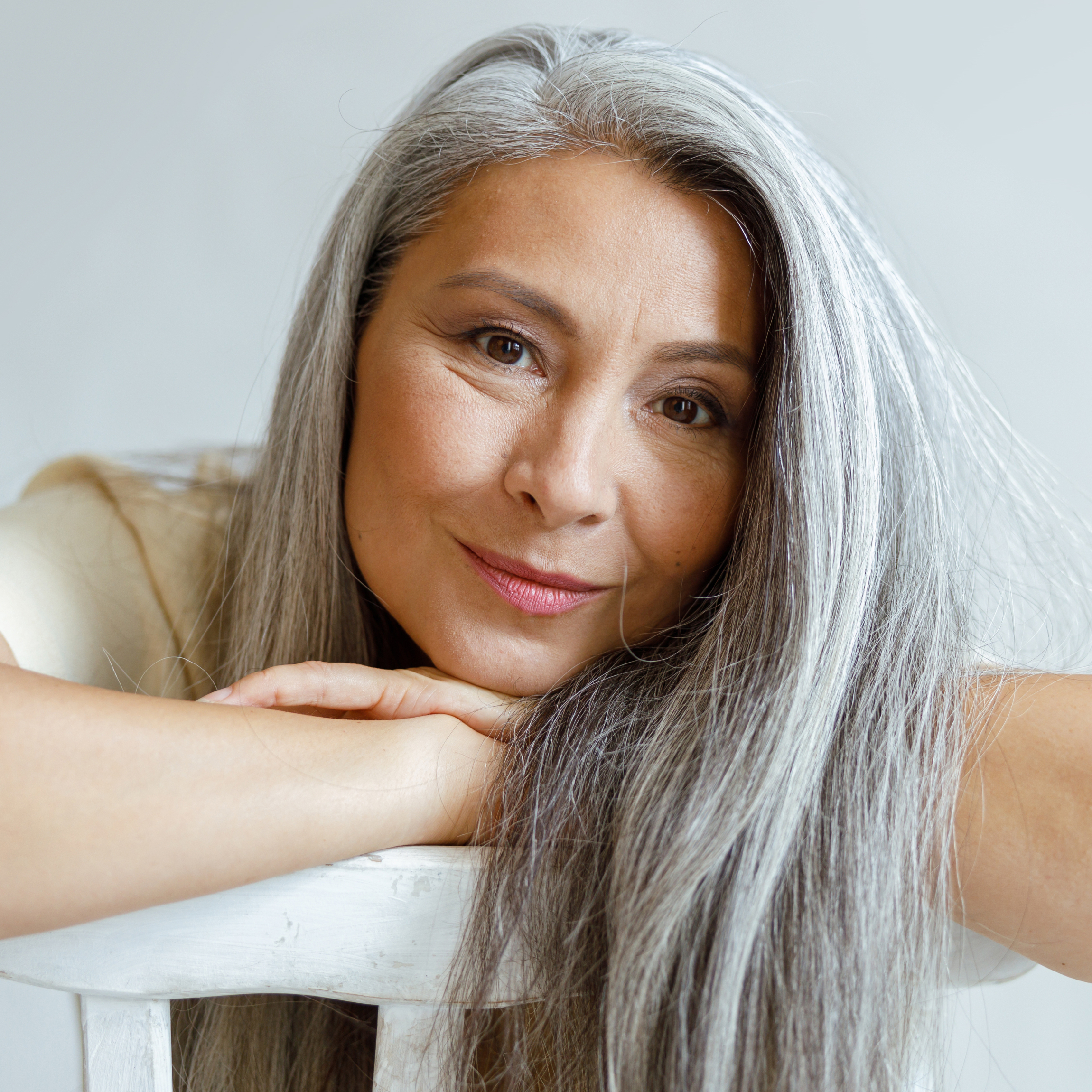 Older woman with very thick-looking gray hair smiling. 