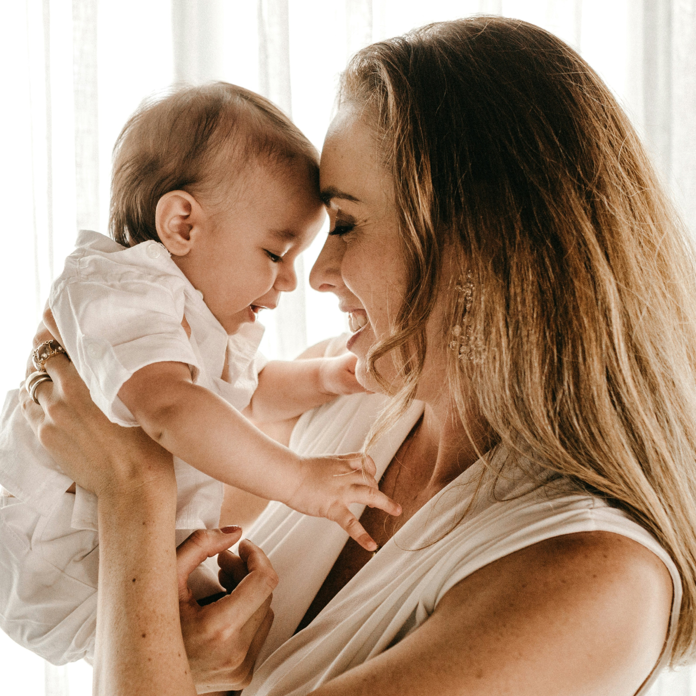 Woman holding her baby and smiling. 