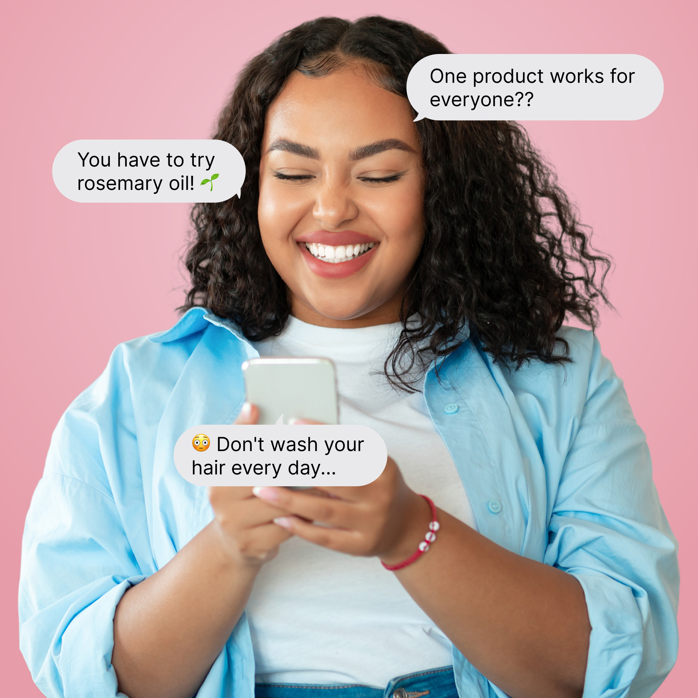 One woman with curly hair looking at her phone and smiling. 