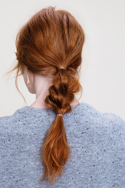 Image of esalon client Dominique's low Bohemian braid with dimensional copper hair color