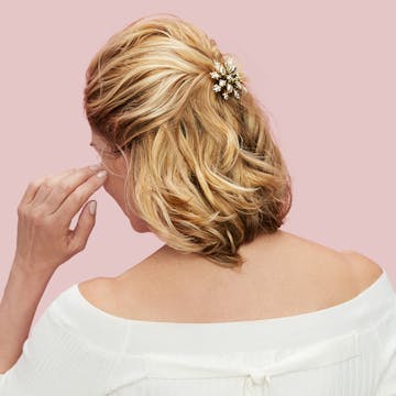 Back of blonde woman's head with a snowflake bow in her hair. 
