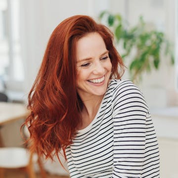 Smiling woman with long red hair. 