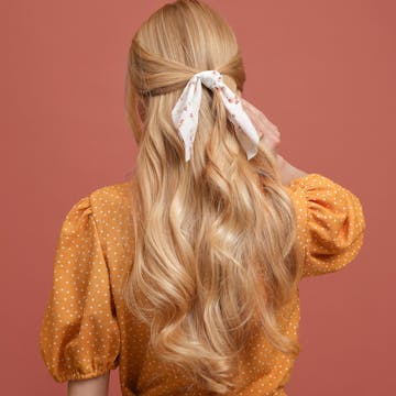 Woman with blonde hair tied in a bow. 