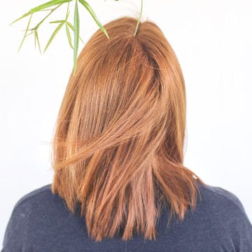 Image of esalon client with a burst of copper hair color featured in color mastery spring trends article