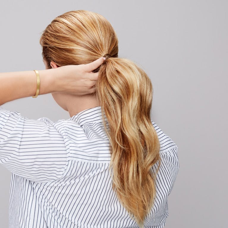 Image of esalon client renee's back of head shot with blonde hair and highlights in a sleek ponytail in this how to article featured in color mastery