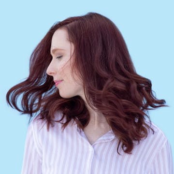 Image of woman from the side with esalon custom home hair color in bright warm merlot trending for spring
