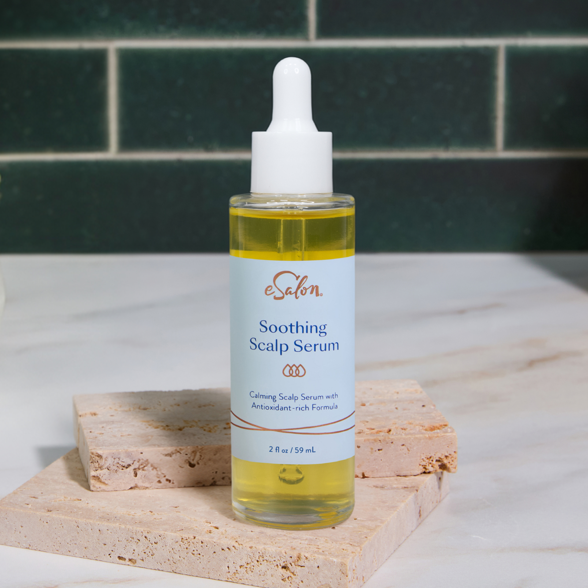 A bottle of eSalon Soothing Scalp Serum on a marble bathroom counter with plants in the background.