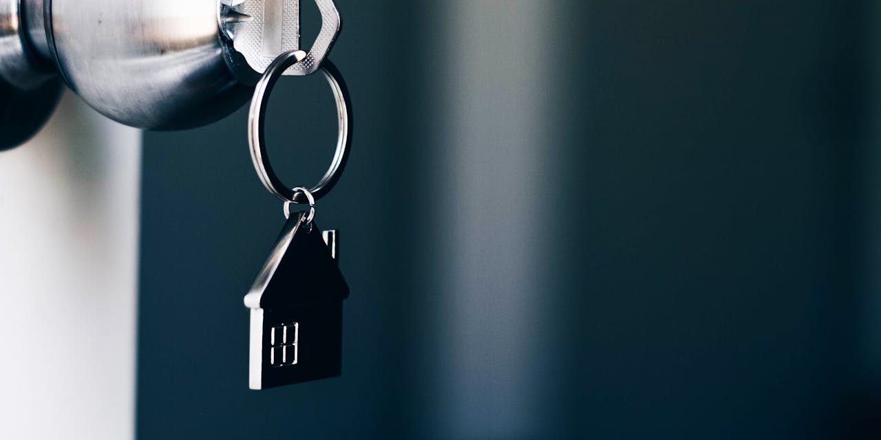 Property Concept, Home key with metal house keychain in keyhole