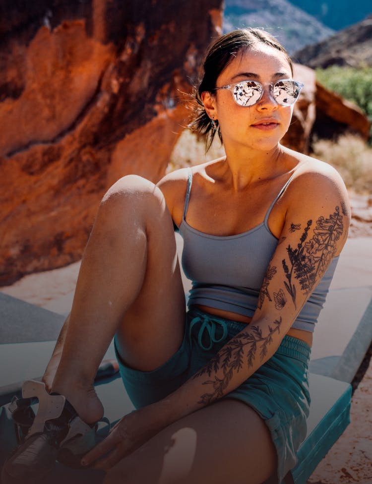 Woman rock climbing wearing ROKA sunglasses