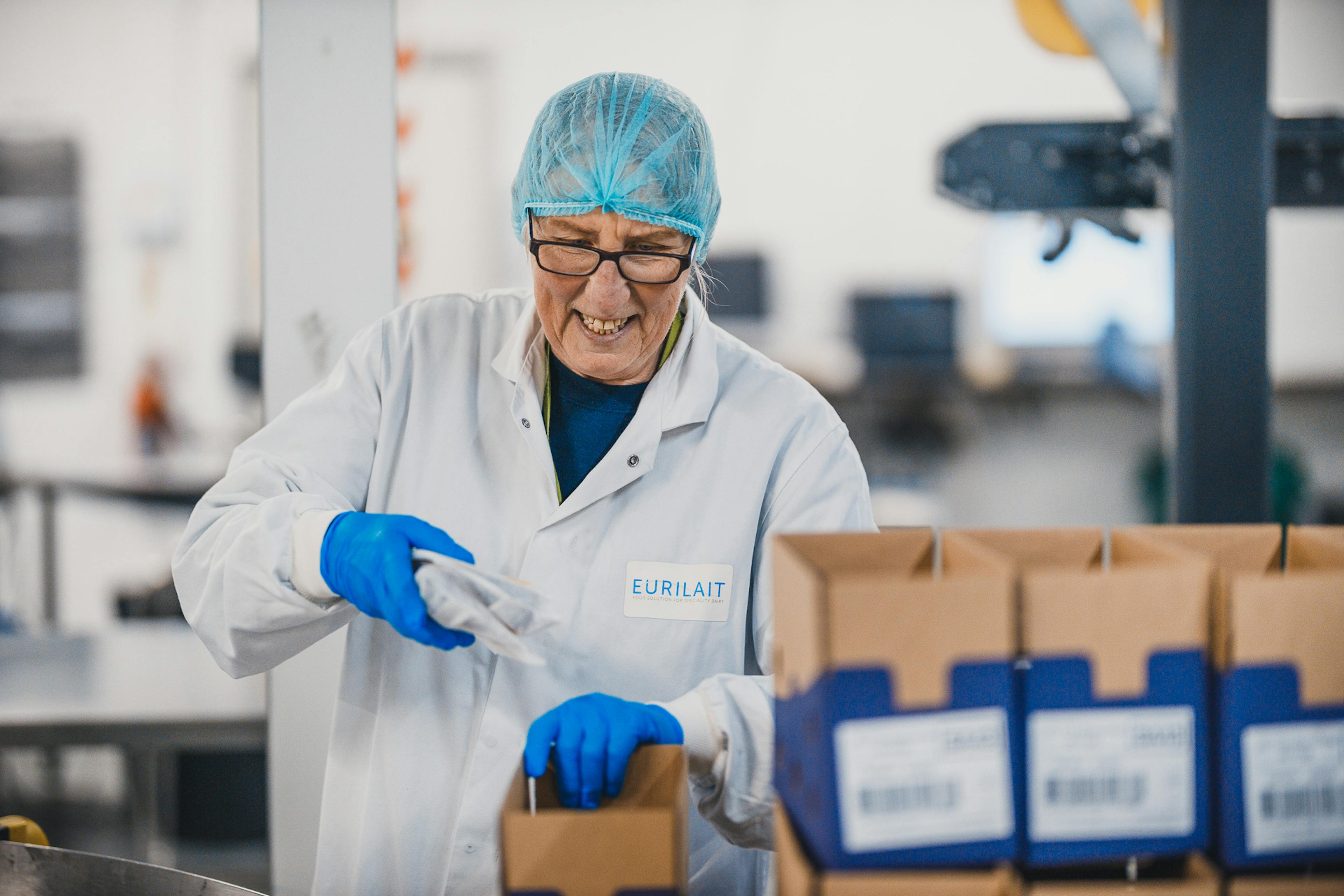 Food factory worker packing cheese