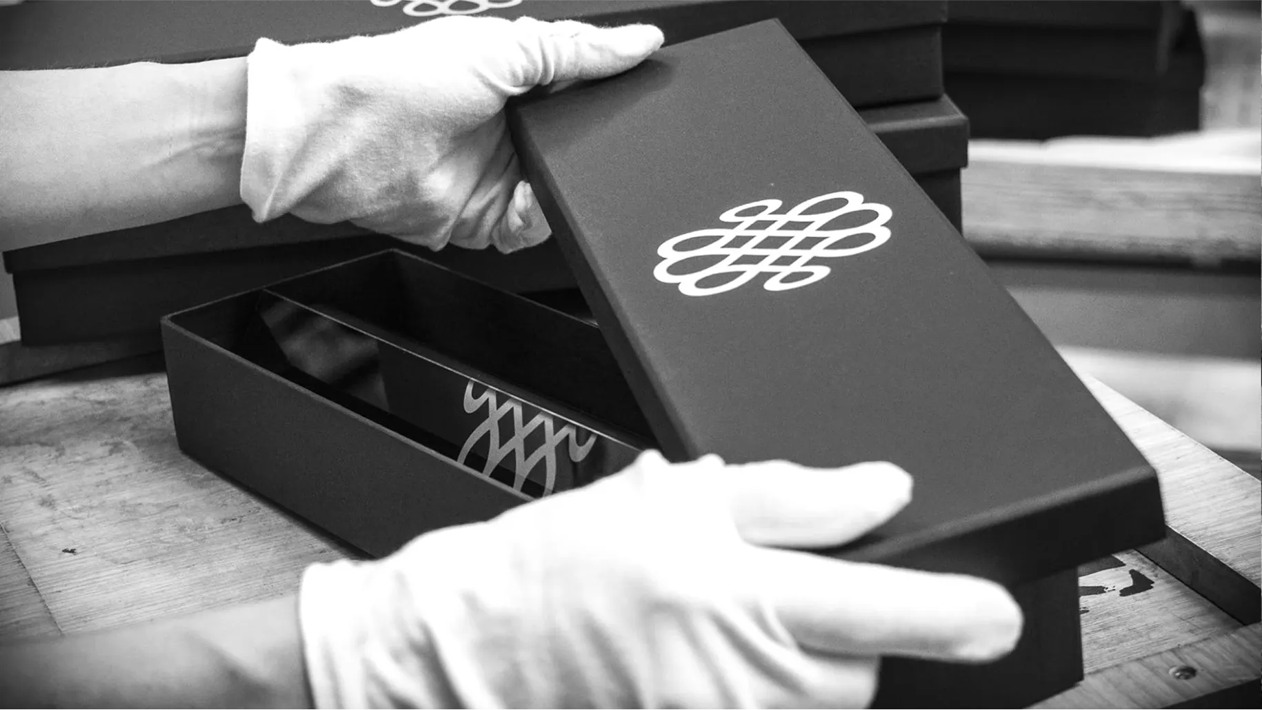 White-gloved hands opening a black EuroCave monogram gift box, reflecting the exceptional craftsmanship honoured by the 2021 Entreprise du Patrimoine Vivant label.