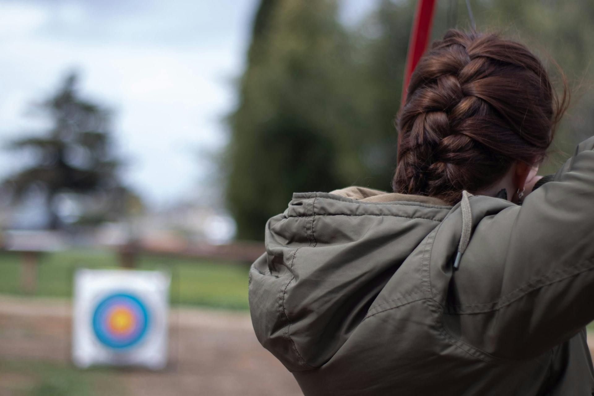 Woman shooting at archery target.