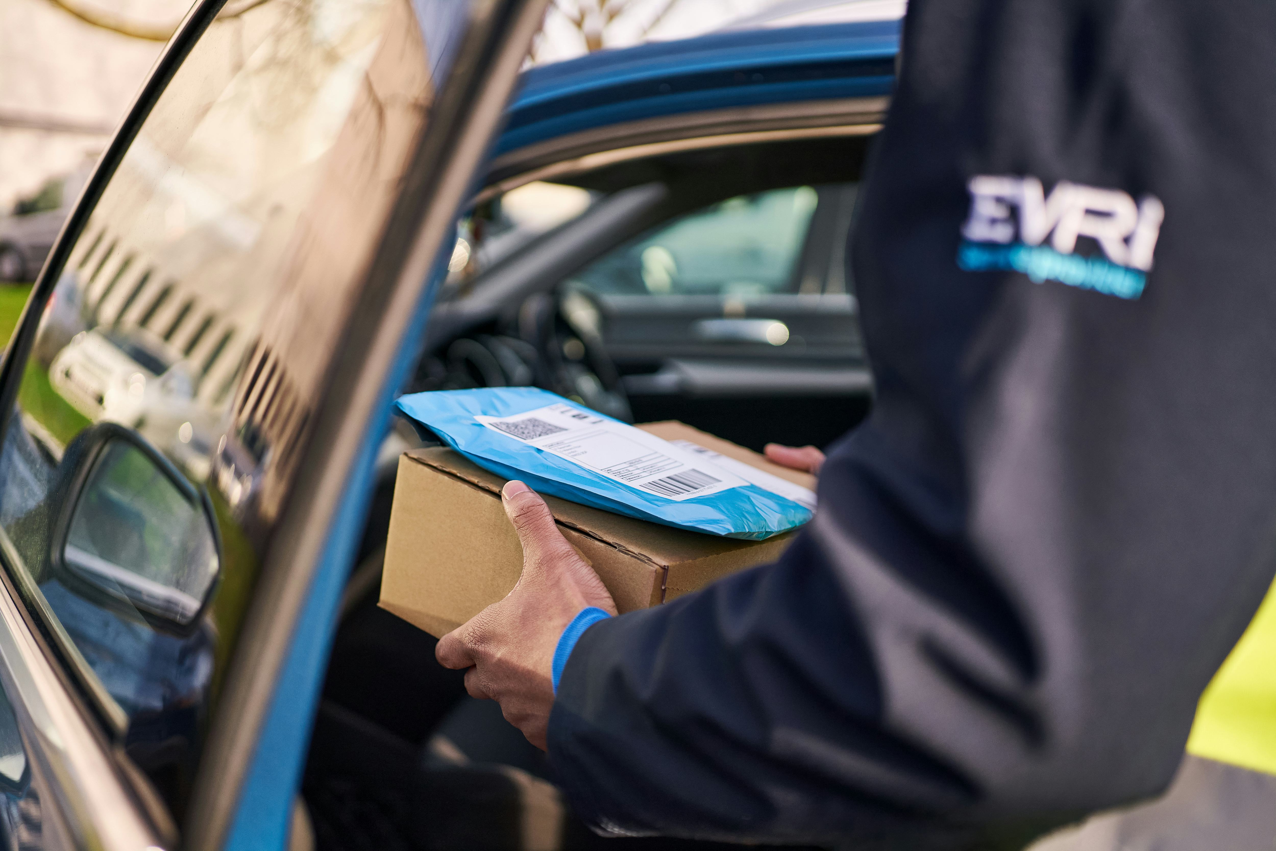 Courier taking a parcel out of a van