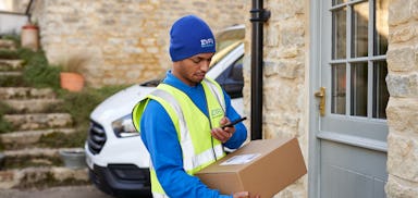 Photo of a courier holding parcel on doorstep and scanning on smartphone