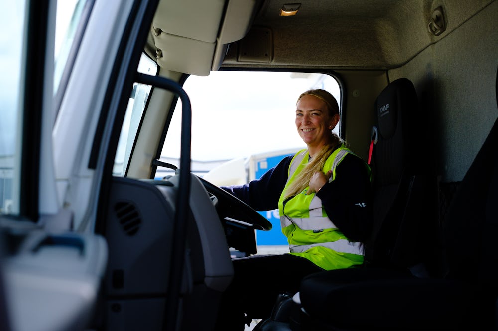 Female lorry driver sat in the cab of her vehicle