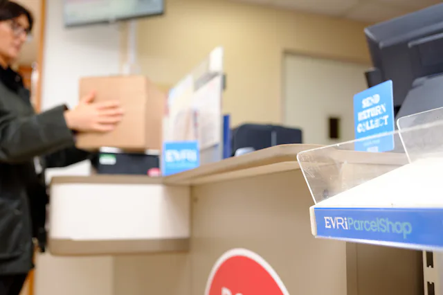Woman weighing parcel at Post Office
