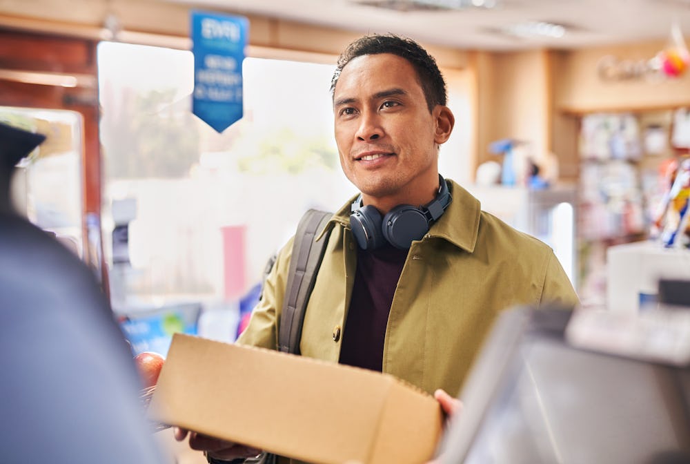 Photo of a customer holding parcel at shop counter