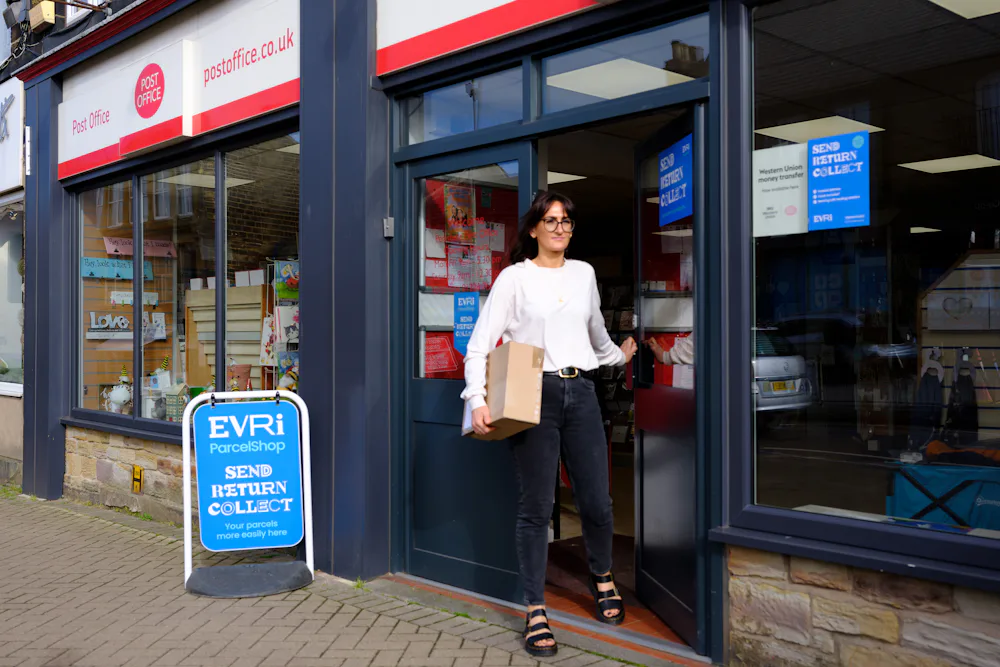 Woman collecting parcel from Post Office