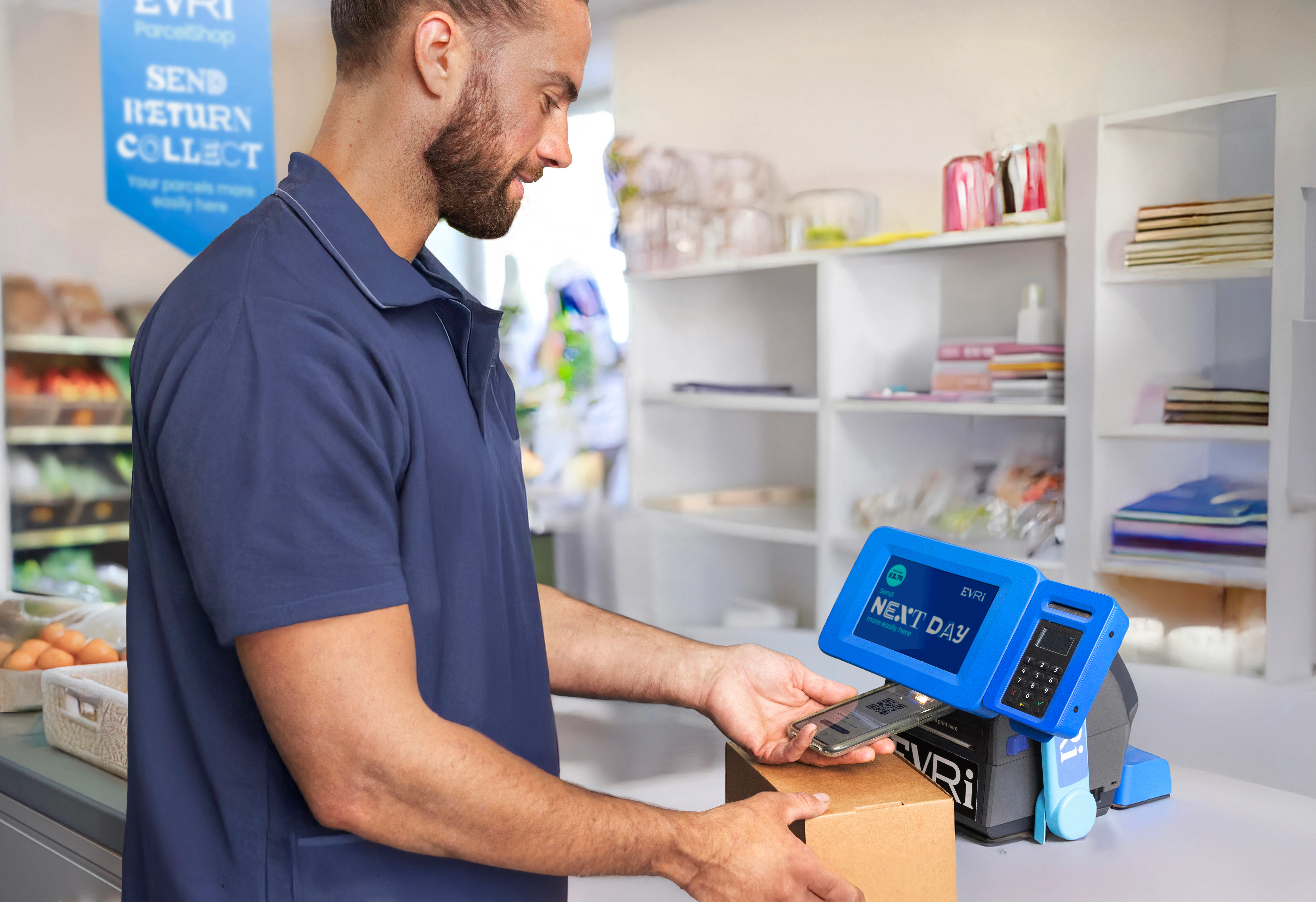 Customer in a ParcelShop store scanning their parcel's QR code using a Print in Store device to print their label for sending.