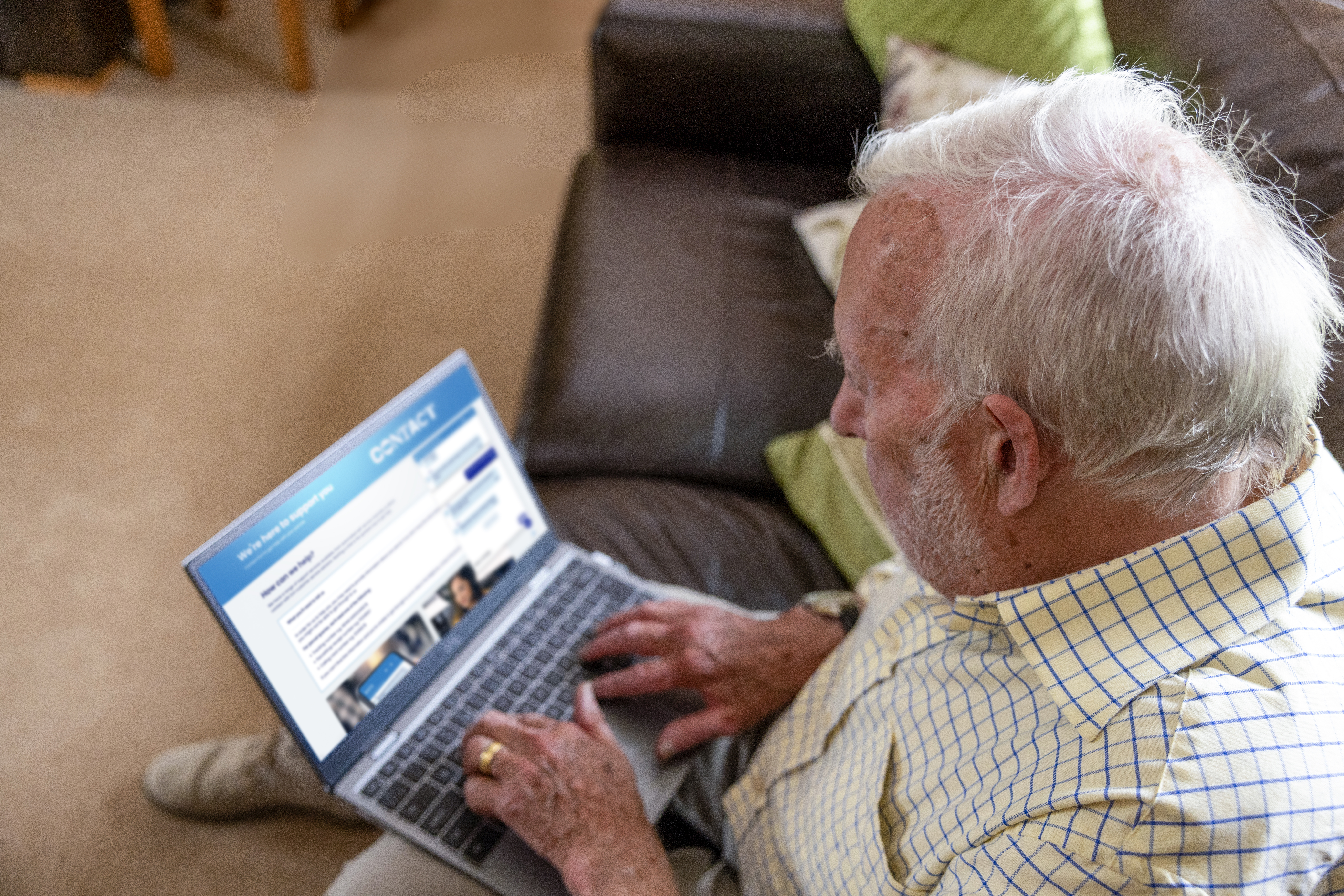 An older man is navigating the Evri website. The help page is visible on his screen. The photo is taken from his perspective.