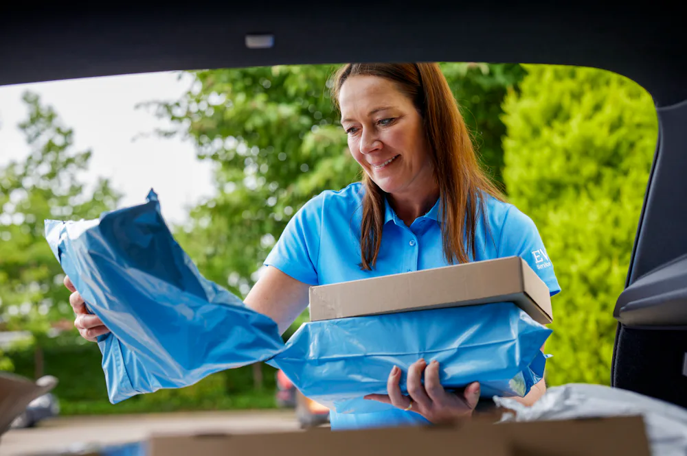 An Evri Courier gathering multiple parcels from their car to deliver to their destination